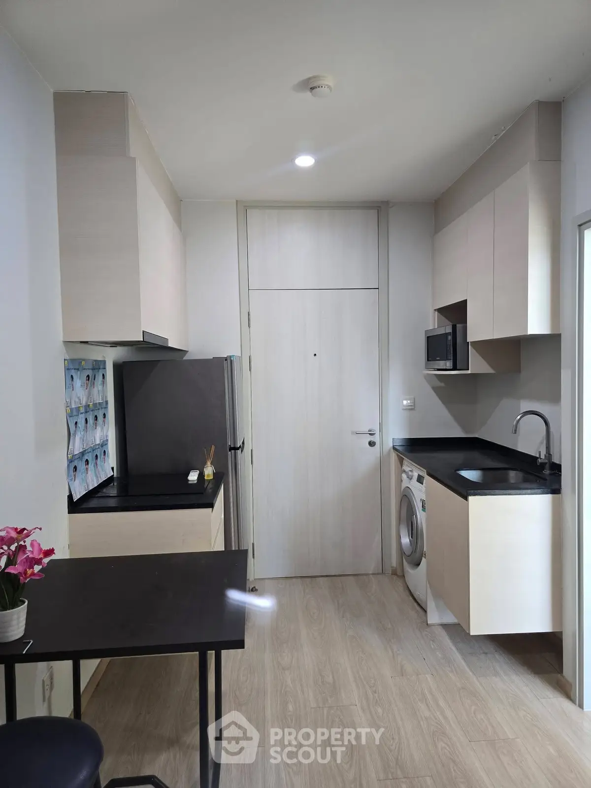 Modern compact kitchen with sleek cabinetry and integrated appliances in a stylish apartment.