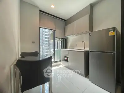 Modern kitchen with sleek cabinetry and stainless steel appliances in a high-rise apartment.