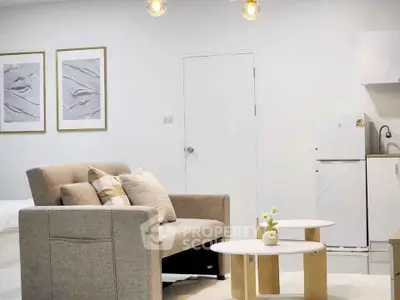 Modern living room with cozy sofa, stylish decor, and compact kitchen area in a bright apartment.