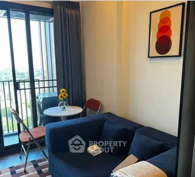 Cozy living room with balcony view, modern decor, and natural light.