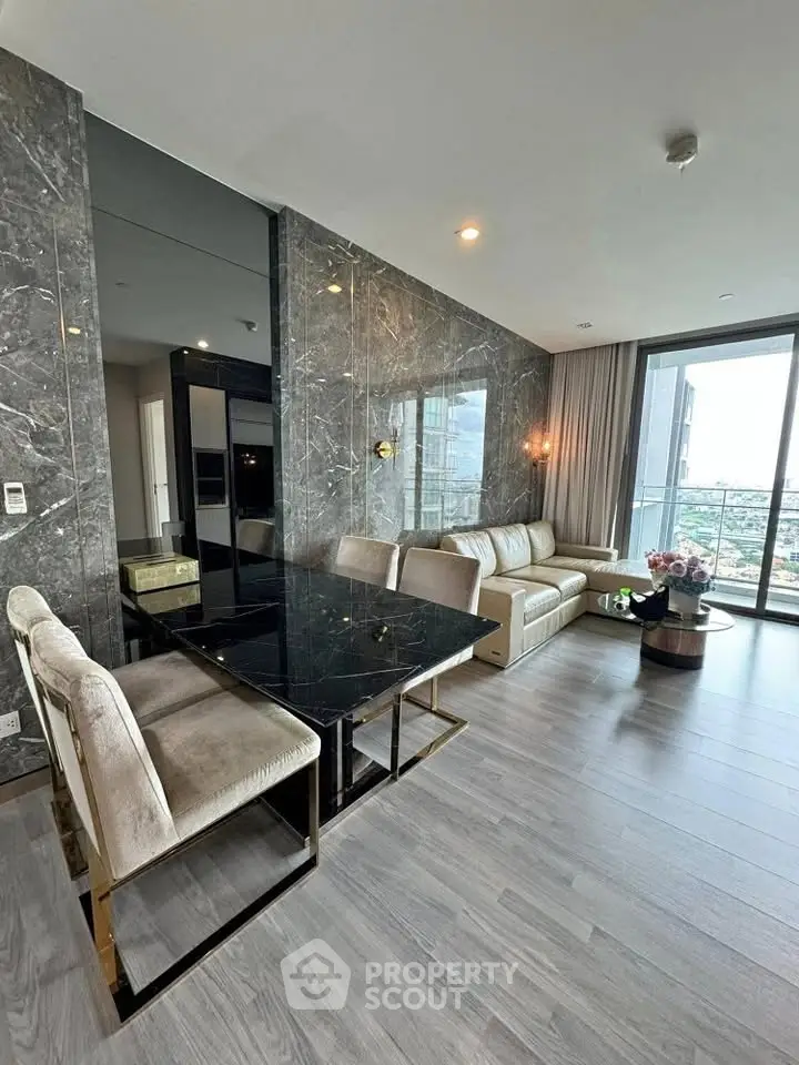 Luxurious modern living room with marble walls and stunning city view from balcony.