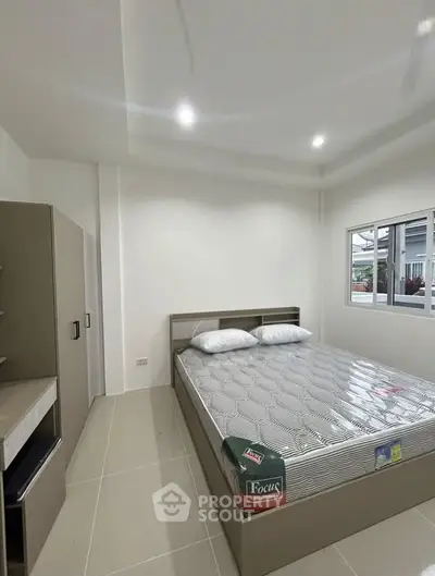 Modern bedroom with sleek design and natural light, featuring a comfortable bed and ample storage space.