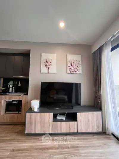 Modern living room with stylish TV stand and wall art, featuring sleek wooden flooring and elegant curtains.
