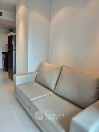 Modern living room with sleek sofa and open kitchen layout in a stylish apartment.