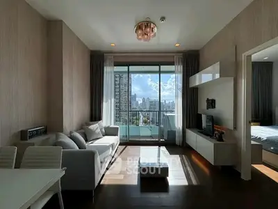 Luxurious living room with modern decor and stunning city view from balcony.