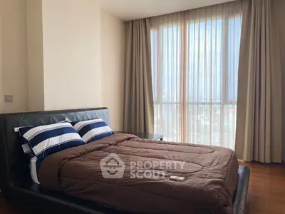 Cozy bedroom with large window and elegant curtains, featuring a stylish bed and modern decor.