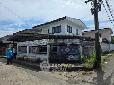 Charming two-story house with unique architectural design and spacious outdoor area.