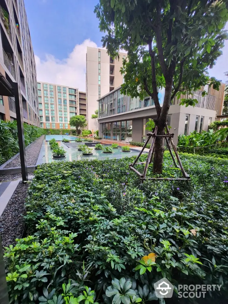 Modern residential building with lush garden and serene water feature