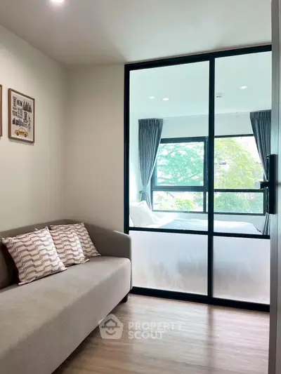 Modern living room with glass partition and cozy sofa in stylish apartment.