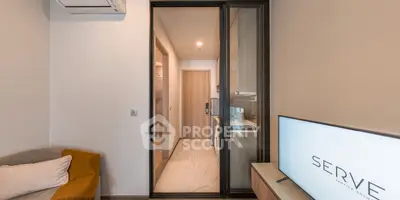 Modern apartment interior with sleek kitchen and cozy living area, featuring air conditioning and stylish decor.