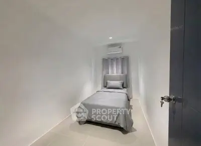 Minimalist bedroom with single bed and air conditioning in modern apartment.