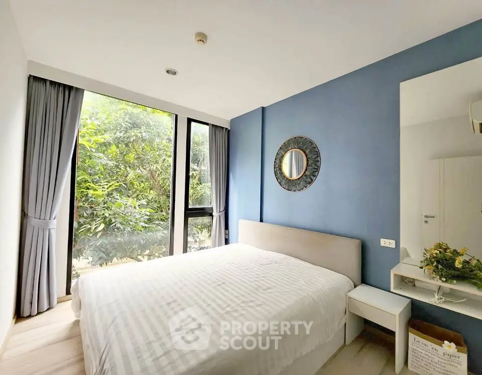 Bright and cozy bedroom with large window and stylish decor