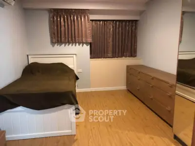 Cozy bedroom with wooden flooring and ample storage space in modern apartment.