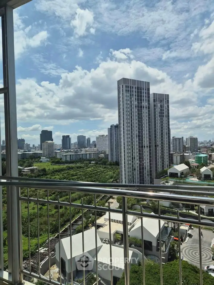 Stunning cityscape view from a high-rise balcony overlooking modern skyscrapers and lush greenery.