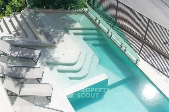 Luxurious outdoor pool area with modern design and sun loungers, perfect for relaxation and leisure.