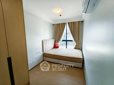 Cozy bedroom with large window and modern furnishings in a stylish apartment.