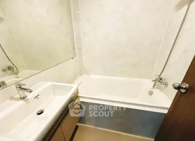 Modern bathroom with sleek bathtub and elegant fixtures in a stylish real estate property.