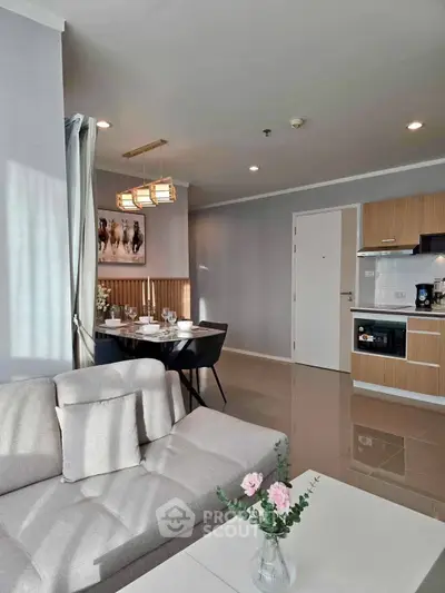 Modern living room with open kitchen, stylish decor, and natural light