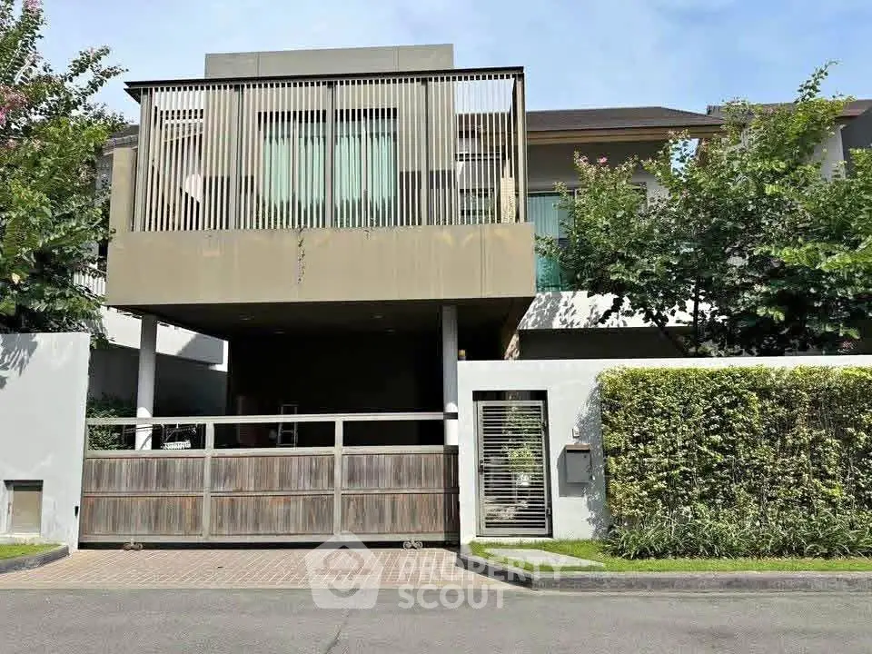 Modern luxury home with sleek facade and lush greenery in upscale neighborhood.