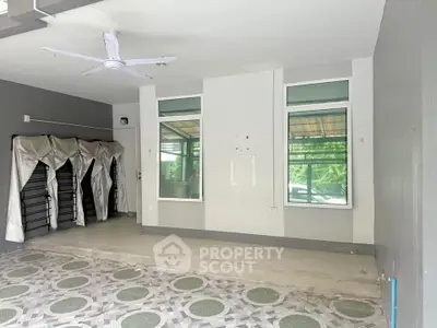 Spacious room with tiled floor and large windows, ideal for versatile use.