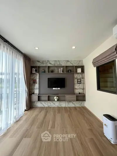 Spacious modern living room with elegant wood flooring and built-in TV unit, perfect for stylish living.