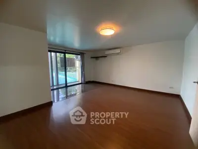 Spacious living room with pool view and wooden flooring