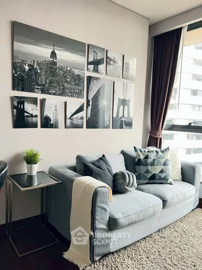 Stylish living room with modern decor and cityscape wall art, cozy sofa, and natural light.