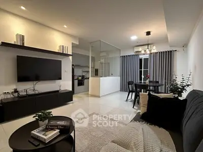 Modern living room with open kitchen, sleek decor, and cozy ambiance in a stylish apartment.
