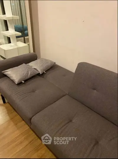 Modern living room with stylish gray sofa and wooden flooring, perfect for cozy relaxation.