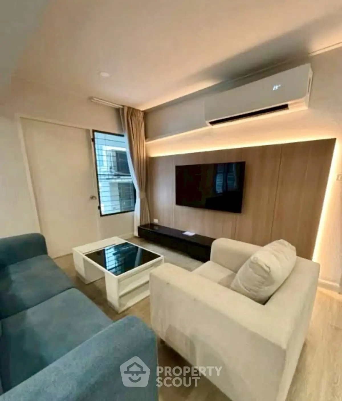 Modern living room with sleek furniture and wall-mounted TV, featuring ambient lighting.