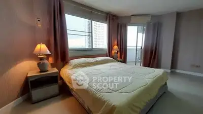 Spacious bedroom with large window and balcony access in modern apartment.