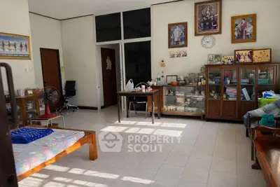 Spacious living room with natural light, traditional decor, and ample storage space.