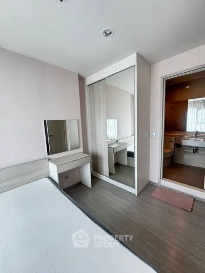 Modern bedroom with mirrored wardrobe and ensuite bathroom