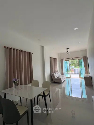 Spacious modern living room with large windows and elegant dining area