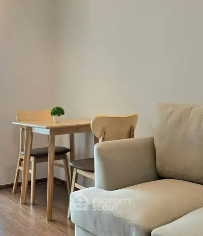 Modern living room with cozy beige sofa and minimalist wooden dining set.