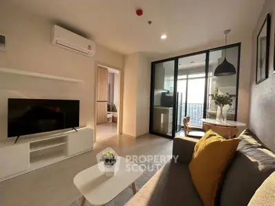 Modern living room with balcony, stylish decor, and ample natural light.