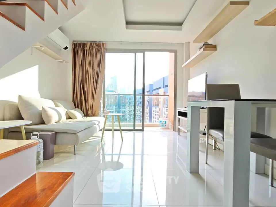 Bright modern living room with large windows and city view, featuring stylish furniture and open layout.