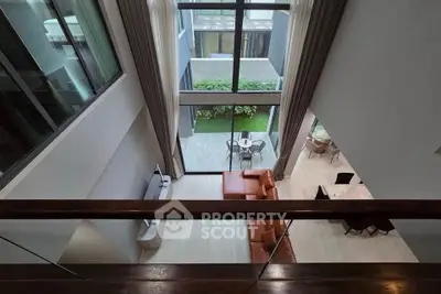Stunning modern living room with high ceilings and large windows overlooking a private garden.