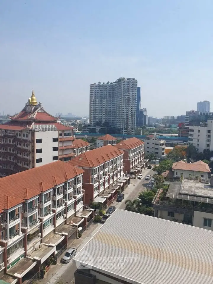 Stunning cityscape view showcasing modern high-rise buildings and charming townhouses under a clear blue sky.