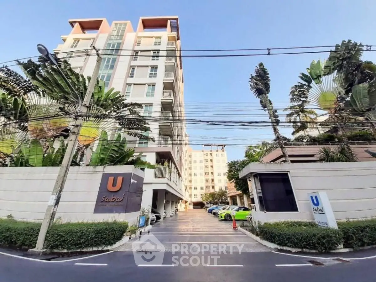 Modern condominium building with lush greenery and ample parking space