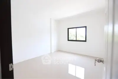 Spacious empty room with bright window and glossy tiled floor