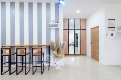 Modern interior with stylish bar stools and striped accent wall in a contemporary living space.