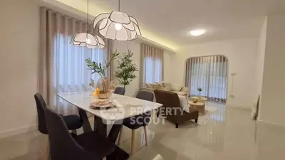 Elegant living room with modern dining area and stylish lighting fixtures.
