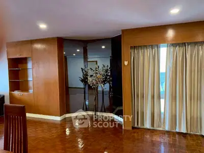 Spacious living room with elegant wooden flooring and built-in shelves