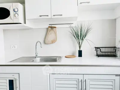 Modern kitchen with sleek white cabinets and stainless steel sink
