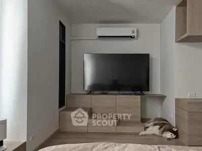 Modern living room with sleek TV setup and air conditioning, featuring a cozy corner for relaxation.