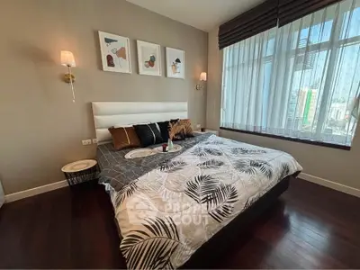 Luxurious bedroom with elegant decor and large window offering city views