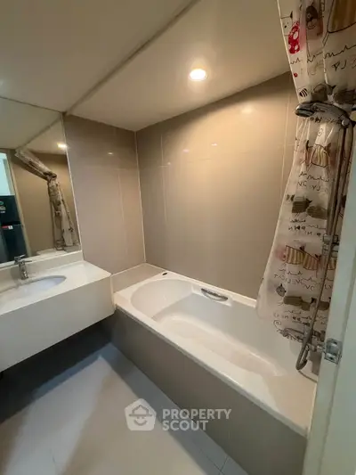 Modern bathroom with sleek bathtub and stylish shower curtain in a contemporary apartment.