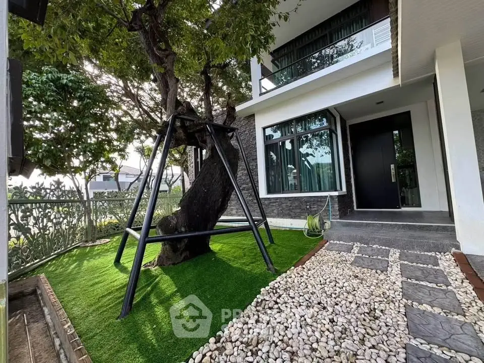 Modern home exterior with lush garden and unique tree swing feature.