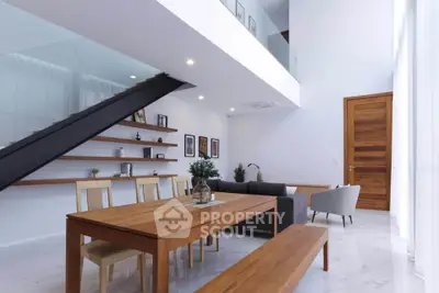 Modern open-plan living and dining area with stylish furniture and high ceilings.